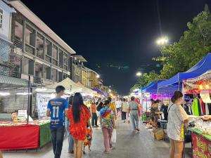 a group of people walking through a market at night at Los Inn Nakhon ลอส อินน์ นคร in Nakhon Phanom