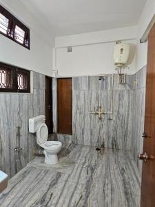 uma casa de banho com um WC e um chuveiro em Bhaskar Homestay - The Bungalow em Dibrugarh