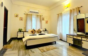 um quarto com uma cama, uma cómoda e um espelho em Bhaskar Homestay - The Bungalow em Dibrugarh