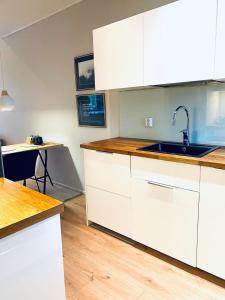 a kitchen with white cabinets and a sink at Ihana huoneisto - The Nest with Sauna in VAASA in Vaasa