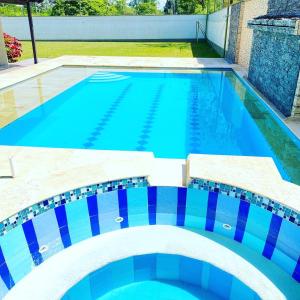 una piscina con azulejos azules en la parte superior en CASA LOS PORTILLOS, en Restrepo