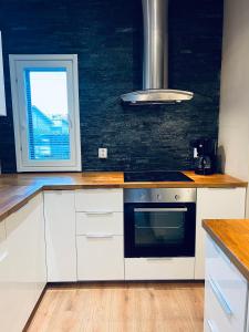 a kitchen with white cabinets and a stove top oven at Ihana huoneisto - The Nest with Sauna in VAASA in Vaasa