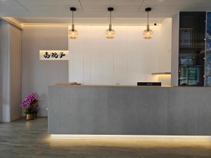 a lobby with a reception counter with lights and flowers at 亮院子旅墅 Bright Courtyard in Datong