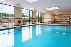 a swimming pool with blue water in a building with windows at Sheraton West Des Moines in West Des Moines