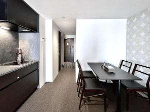 a kitchen and dining room with a table and chairs at Apartment Hotel 11 Namba in Osaka