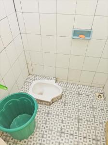 a bathroom with a toilet and a bucket on the floor at SLAMET HOMESTAY TASIKMALAYA in Tasikmalaya