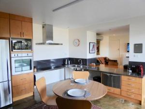 a kitchen with a table and chairs in it at Spacious Apartment - Warm and Welcoming in Lindisfarne, 8 min from CBD in Lindisfarne