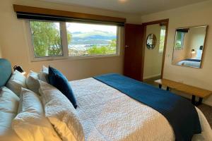 1 dormitorio con 1 cama grande y ventana grande en Spacious Apartment - Warm and Welcoming in Lindisfarne, 8 min from CBD en Lindisfarne