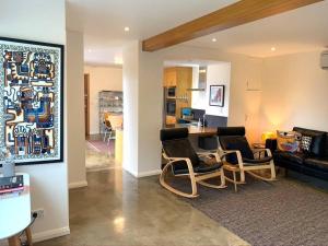 LindisfarneにあるSpacious Apartment - Warm and Welcoming in Lindisfarne, 8 min from CBDのリビングルーム(椅子、テーブル、ソファ付)
