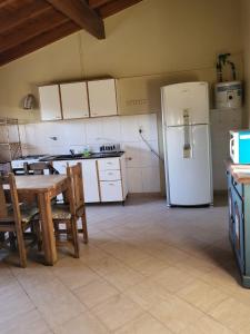 Departamento Mendoza في مايبو: مطبخ مع طاولة وثلاجة