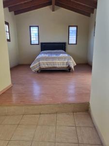 Departamento Mendoza في مايبو: غرفة نوم بسرير وارضية خشبية
