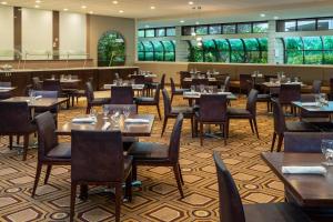 a restaurant with tables and chairs in a room at Sheraton Tampa Brandon Hotel in Tampa