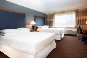 a hotel room with two beds and a window at Sheraton Niagara Falls in Niagara Falls
