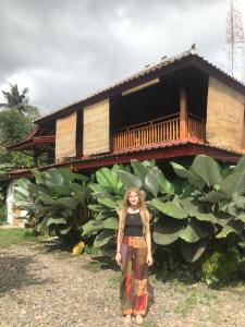 a woman standing in front of a banana plantation at Provok bungalows in Sangyang