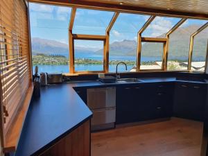 a kitchen with a view of the water and mountains at Luxury Home with Beautiful Lake & Mountain Views in Queenstown