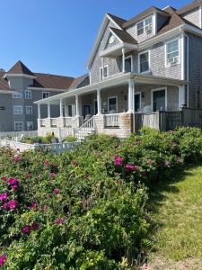 a house with pink flowers in front of it at Inkwell Beach Cottage in Oak Bluffs