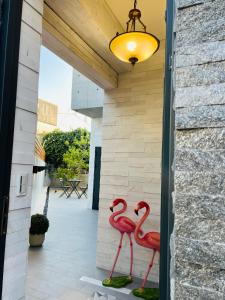 Deux flamants roses sont assis sur une terrasse couverte dans l'établissement 日日見宅 Matsuya, à Huwei