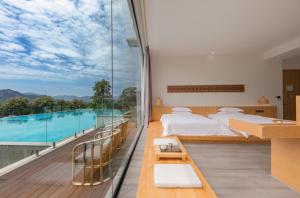 張家界的住宿－Avatar Mountain Resort，一间带两张床的卧室和一个带游泳池的阳台