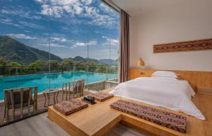 a bedroom with a bed and a view of a pool at Avatar Mountain Resort in Zhangjiajie
