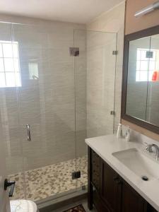 a bathroom with a glass shower and a sink at Beautiful house in lake worth,close to the beach! in Lake Worth