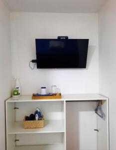 a television on a wall above a white desk at Residencial SOL NACIENTE in Pozo Almonte