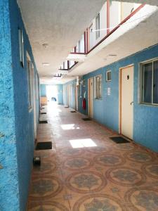 einen leeren Flur mit blauen Wänden und Fliesenboden in der Unterkunft Residencial SOL NACIENTE in Pozo Almonte