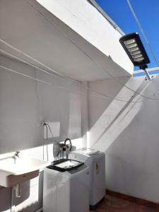 um quarto branco com um lavatório e uma luz em Residencial SOL NACIENTE em Pozo Almonte