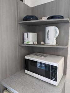 a white microwave on a counter in a kitchen at Y Motels Rockhampton in Rockhampton