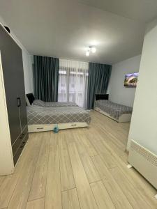 una camera con 2 letti e un pavimento in legno di Танхаус в Байтур резорте и Спа a Bosteri