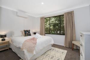 - une chambre blanche avec un lit et une fenêtre dans l'établissement Toorak Place, à Bright