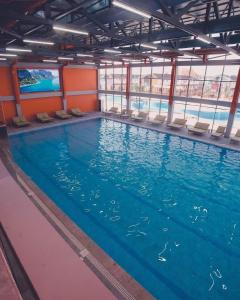 una grande piscina con sedie in un edificio di Танхаус в Байтур резорте и Спа a Bosteri