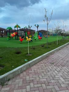een park met een speeltuin met glijbanen en bomen bij Танхаус в Байтур резорте и Спа in Bosteri