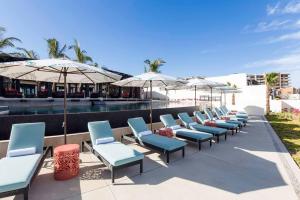 uma fila de cadeiras e guarda-sóis ao lado de uma piscina em Breathtaking Ocean Views and Access Best Resorts! em Cabo San Lucas