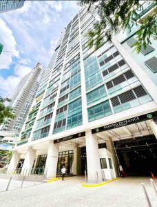 a large tall building with a person standing in front of it at One Uptown Residence Prime Loc BGC,Uptown Linked 1BR,Washer,200mbps in Manila
