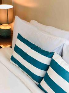 a bed with two blue and white pillows on it at One Uptown Residence Prime Loc BGC,Uptown Linked 1BR,Washer,200mbps in Manila