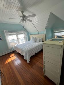 sypialnia z łóżkiem i wentylatorem sufitowym w obiekcie Inkwell Beach Cottage w mieście Oak Bluffs