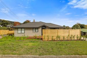 a house with a wooden fence in a yard at Redwoods Adventure Base in Rotorua