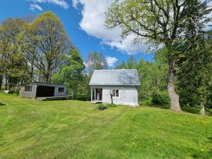 JõgeharaKalla Puhkemaja的一块田野上的小白棚,有树