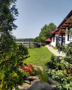 un jardín con flores y una casa y una valla en Domki nad Cichym Dworkiem en Polańczyk