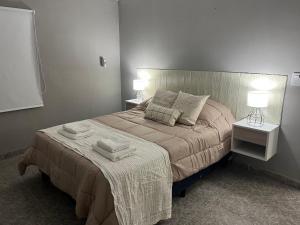 a bedroom with a bed with two towels on it at Departamento frente a plaza libertad 1hab in Santiago del Estero