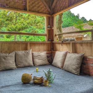 Habitación con sofá y fruta en el suelo en Farmstay Manangel en Sindanglaka
