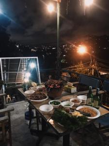 a table with bowls of food on a balcony at night at Crush Va Toi in Da Lat