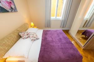 a living room with a couch and a purple rug at Apartment Colona in Zadar