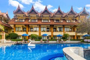 a swimming pool with a swan in front of a hotel at Diamond Cottage Resort & Spa - SHA Extra Plus in Karon Beach