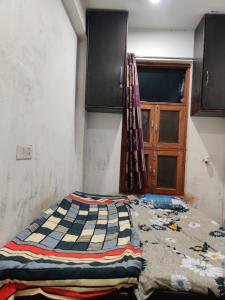 a bedroom with a quilt on the floor next to a door at Hotel EPS in Ghaziabad