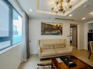 a living room with a couch and a table at Paris Deli Danang Beach Hotel in Danang