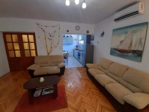 a living room with a couch and chairs and a kitchen at Apartment Marin - 40m from sea in Ston