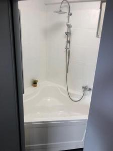 y baño blanco con ducha y bañera. en City Center Green Apartment, en Bucarest