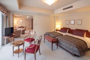 a hotel room with two beds and a television at Hakuba Tokyu Hotel in Hakuba