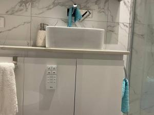 a bathroom with a sink and a white counter at Refurbished Family Home in Glen Waverley